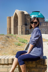 Beautiful young asian woman tourist in front of Mausoleum of Khoja Ahmed Yasawi. Central asia silk...