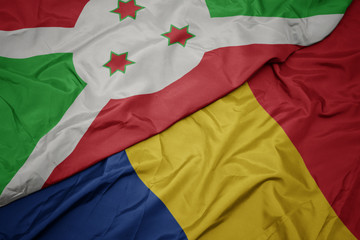 waving colorful flag of romania and national flag of burundi .