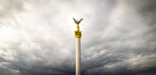 View up to Independence monument on Independence square in Kyiv with dramatic clouds around. Blank space panoramic background image.