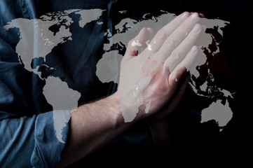 Hands folded in prayer. Repentance. A petition for clemency. Prayer for the whole world. A man is praying. For America and Europe. World map. Prayer for Ukraine.
