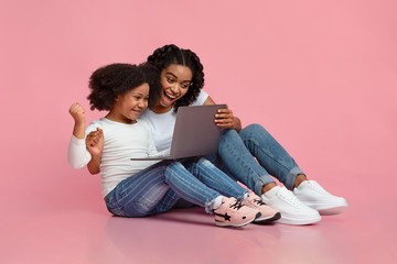 Overjoyed Black Mom And Little Daughter Celebrating Success With Laptop