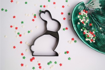 cutting out a cookie stamp for Christmas on a white background with colored stars