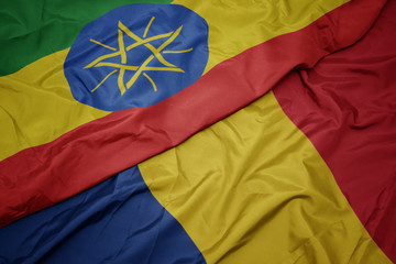 waving colorful flag of romania and national flag of ethiopia .