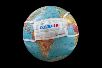 Surgical mask with Covid-19 written on planet Earth white background, Concept . Coronavirus outbreak virus quarantine , 