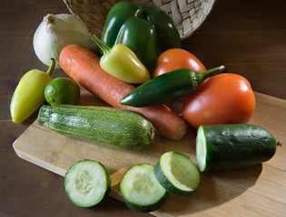 Vegetables on a cutting board in a Mexican kitchen top view with a basket in a background and rim light or back lit