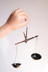 Hand holding Law scales of balance isolated white background. Symbol of justice. Old scales for gunpowder.