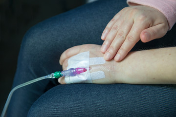 Close-up IV needle on patient hand in the hospital