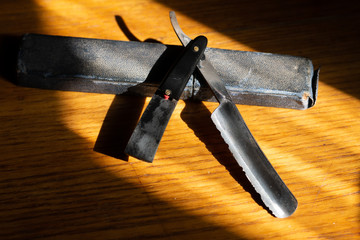 Broken dangerous razor for haircuts on a wooden background. Barber tools on the table.