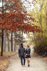 Fototapeta premium Happy interracial couple walking in autumn park