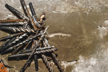 Drills on concrete of different diameter and degree of novelty for a perforator lie on a concrete plate in cracks
