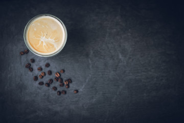 top view cup of cappuccino coffee with a pattern on a dark gray stone background, place for your text, copy space