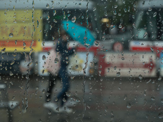 People behind window with umbrellas during rain