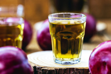 alcoholic drink made from plum, fruit liqueur with rustic wooden background.