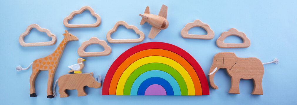 Colorful wooden toys background with rainbow. Preschool, childhood. Zero waste concept.