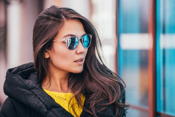 Successful proud self-sufficient woman with glasses in the twilight city - outdoor neon sign lighting