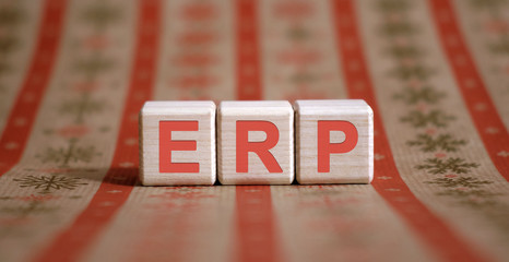 ERP - financial business concept. Wooden cubes on a color table.