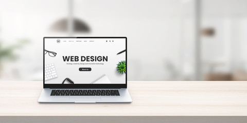 Web design studio promo web site on laptop display on office desk concept
