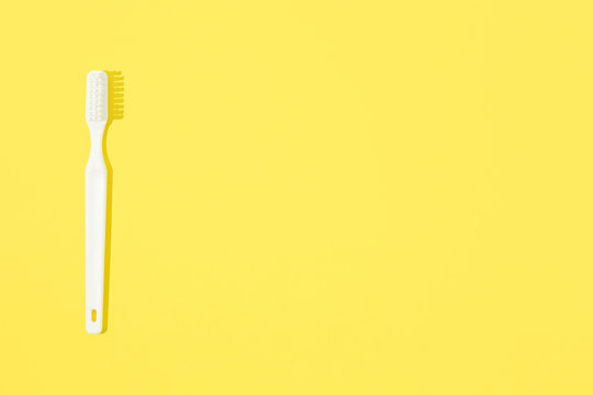 Toothbrush On Yellow Pastel Background.