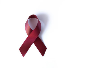 Dark red symbolic ribbon on a white background - support for disabled people, problem of amyloidosis