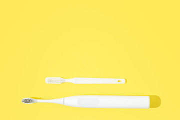 Two toohbrushes classic and sonic on bright yellow pastel background.