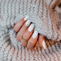 Kobiece dłonie z białymi paznokciami