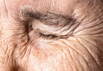 Old age concept. Close-up eye of an elderly woman with a wrinkled face.