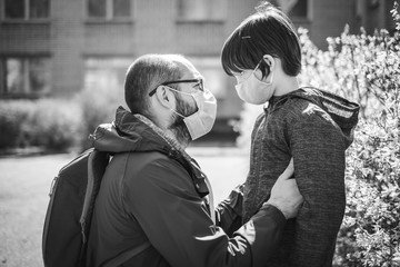Father and son in a medical mask are walking on the street. Virus outbreak
