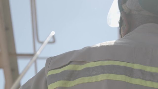 Worker dressing uniform climbing the stairs in industrial environment