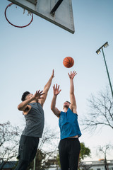 Two young friends playing basketball.