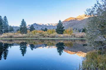 early morning lake with mirrored reflection of mountains