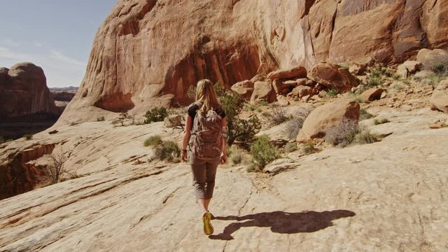 Hiker walks through desert canyon near Moab Utah