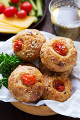 Muffins with cheese, cottage cheese and tomatoes, vegetables and cheese served with wine.