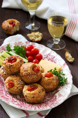 Muffins with cheese, cottage cheese and tomatoes, vegetables and cheese served with wine.