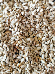 Fried sunflower seeds. The texture of the fried sunflower seeds. Flaky seeds, close-up. Dried peeled sunflower seed for background uses. Roasted dried whole kernels.