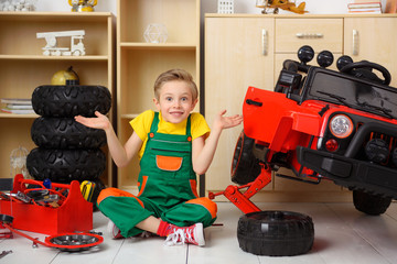 Young boy car mechanic repairing a car. Creative fun of the child.