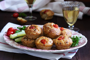 Muffins with cheese, cottage cheese and tomatoes, vegetables and cheese served with wine.
