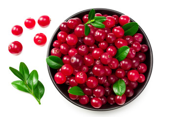 Cranberry in a black plate with green leaves isolated on white background. top view