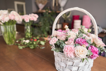 Flower arrangement in a wicker basket. Floral shop concept. Beautiful bouquet of mixed flowers....