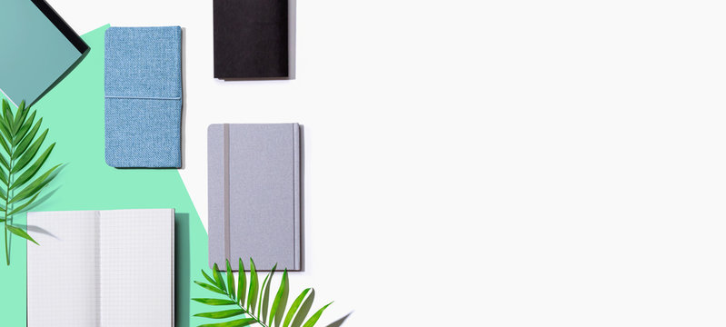 Collection of notebooks with tropical leaves - flat lay
