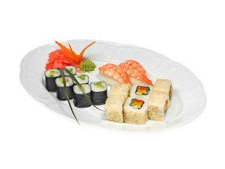 Sushi with shrimps and rolls with cucumber, avocado, paprika and nori. Pickled ginger and wasabi on white oval plate