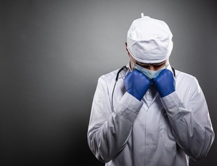Fototapeta na wymiar Overworked tired doctor in white uniform and medical mask.