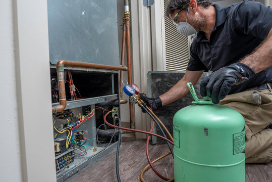 HVAC Technican Wearing A Mask Charging Ac