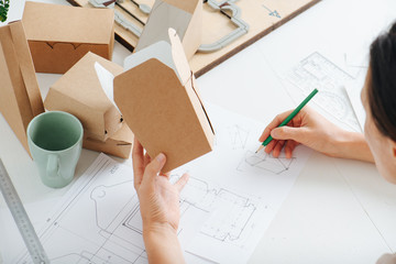 Box maker working behind a table, holding box in her hand