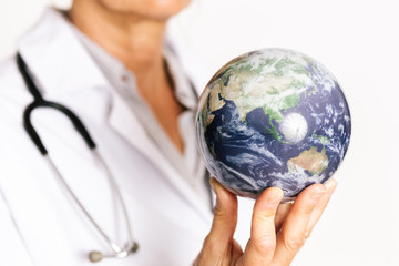 female doctor holding planet earth on her fingertips. Showing australia and asia map