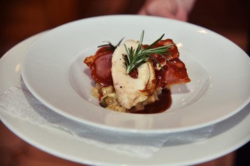 Mit getrockneten Tomaten gefüllte Maispoularde mit Parmaschinken gebraten auf mediterranem Gemüserisotto