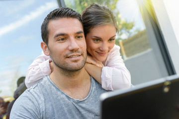 Couple talking and buying something online with a tablet outdoors