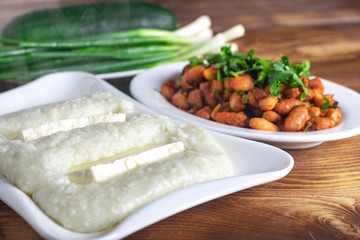 Lobio is a Georgian dish, ghomi and green onion in a plate on wooden table
