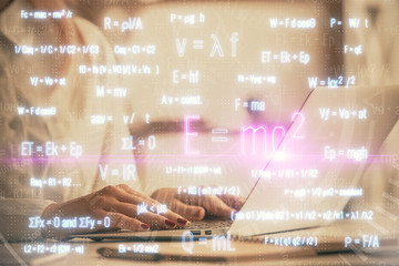 Double exposure of woman hands typing on computer and formula hologram drawing. Education concept.