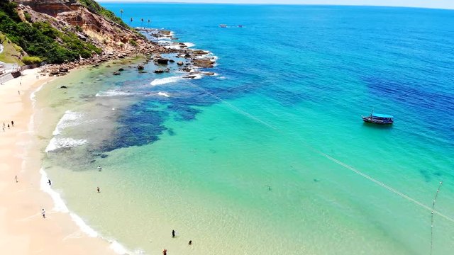 Beautiful First Beach turquoise water and zipline at Morro de Sao Paulo. Tourists enjoying the sun. Tinhare Island, Bahia Brazil. Drone moving up.