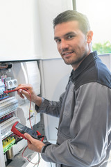 Electrician tests circuit breakers in a electrical panel